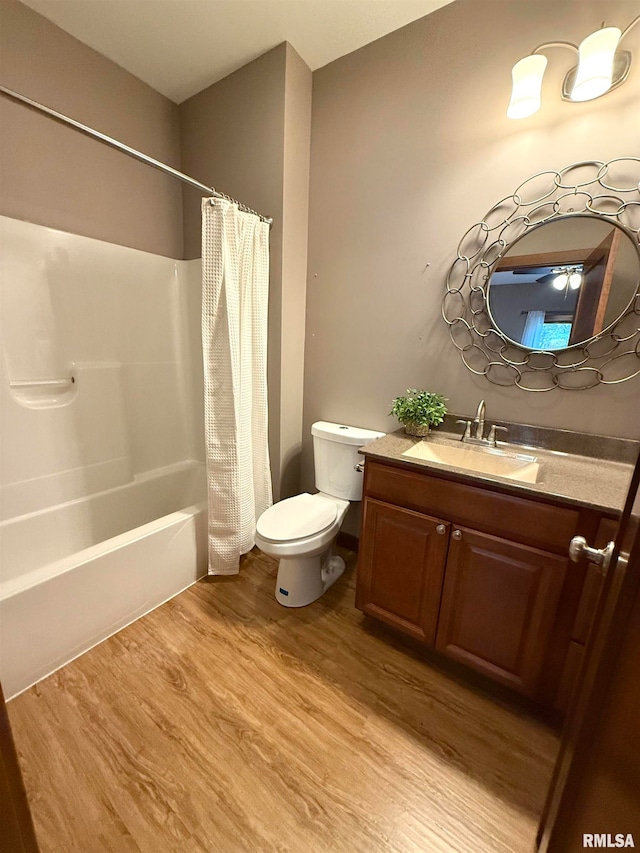 full bathroom with vanity, toilet, wood-type flooring, and shower / tub combo