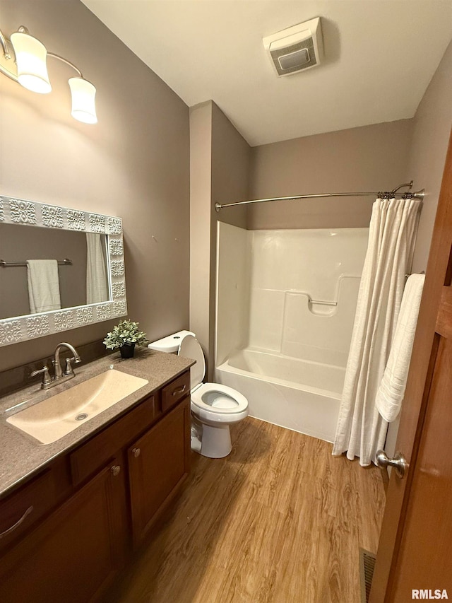 full bathroom with vanity, hardwood / wood-style floors, shower / tub combo, and toilet