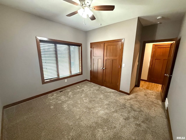 unfurnished bedroom with a closet, ceiling fan, and light colored carpet