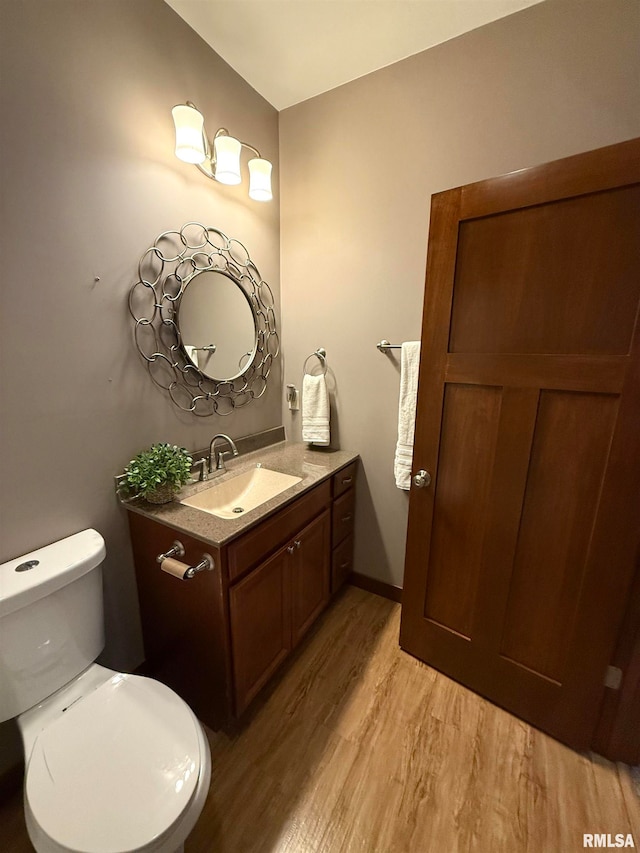 bathroom with vanity, toilet, and wood-type flooring