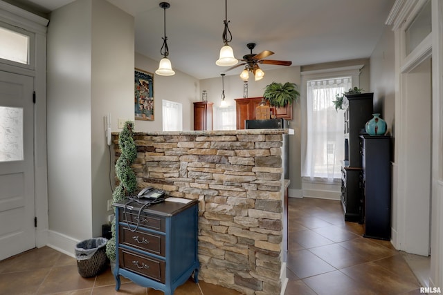 interior space featuring dark tile patterned flooring, a healthy amount of sunlight, and ceiling fan