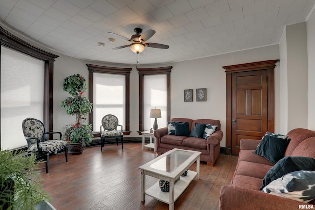 living room with crown molding, dark wood-type flooring, and ceiling fan