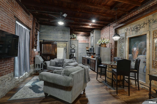 living room with wooden ceiling, a barn door, beamed ceiling, and brick wall