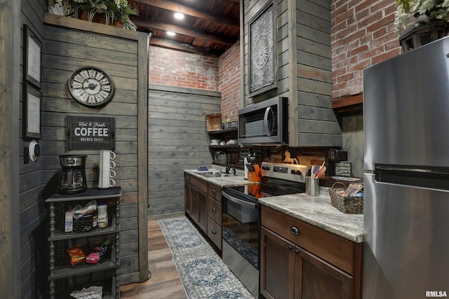 kitchen with sink, beam ceiling, stainless steel appliances, light stone countertops, and wooden ceiling