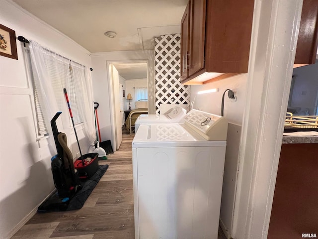 washroom featuring cabinets, washing machine and dryer, and light wood-type flooring