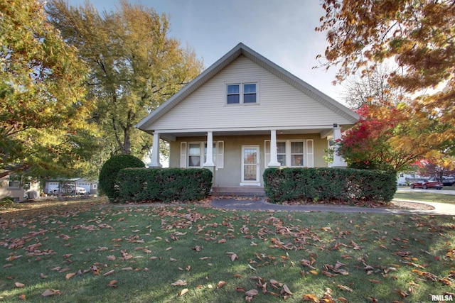 bungalow with a front yard and a porch