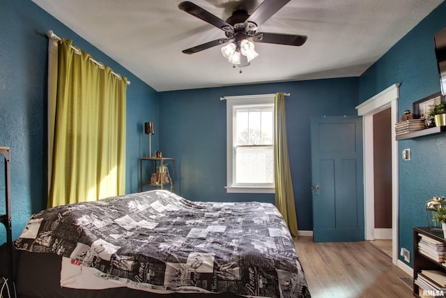 bedroom with light hardwood / wood-style floors and ceiling fan