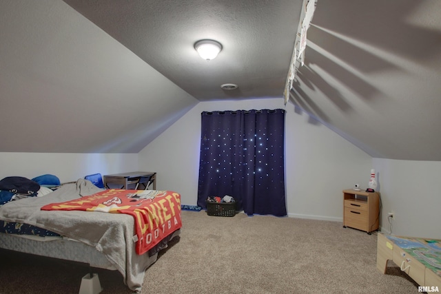 bedroom with lofted ceiling, a textured ceiling, and carpet flooring