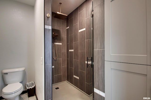 bathroom featuring a tile shower and toilet