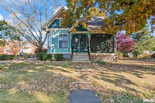 view of front of home featuring a front yard and a sunroom