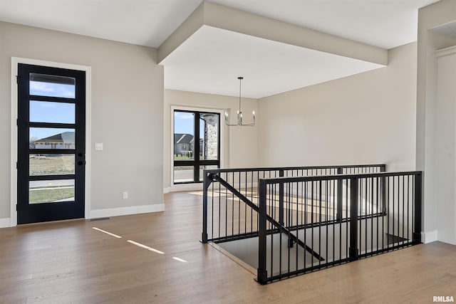 entryway featuring wood-type flooring and a notable chandelier