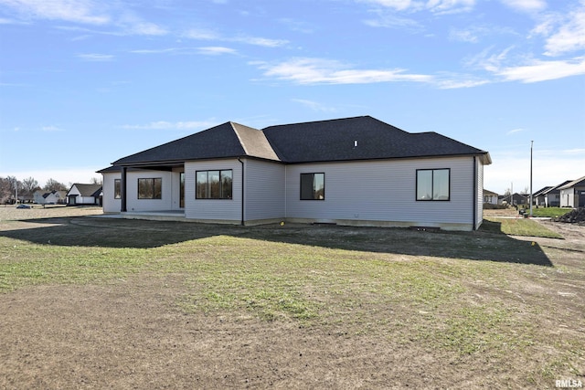 rear view of house with a lawn and a patio area