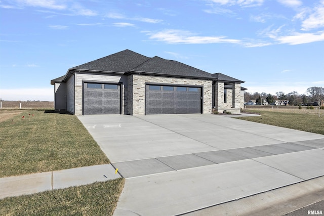 prairie-style house featuring a front yard and a garage