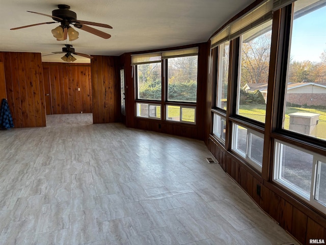 unfurnished sunroom featuring ceiling fan