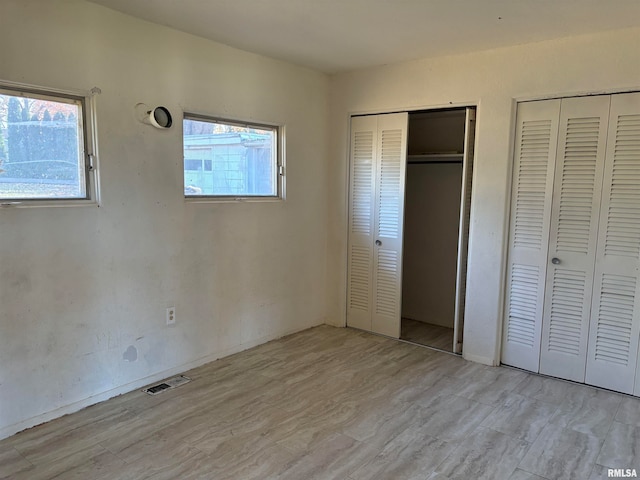 unfurnished bedroom with two closets