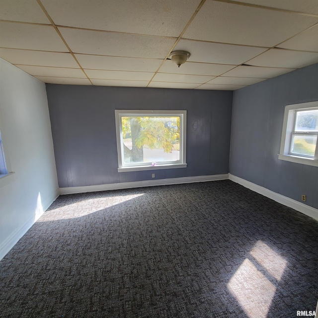 carpeted empty room with a drop ceiling