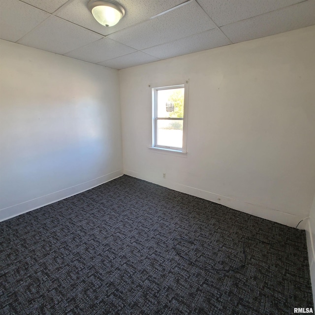 carpeted spare room featuring a drop ceiling