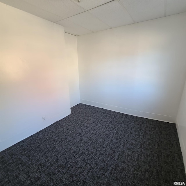 carpeted empty room with a drop ceiling