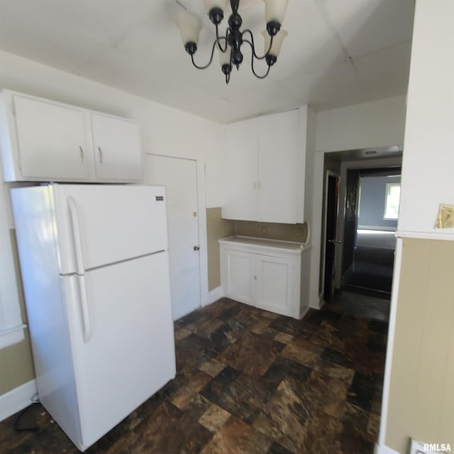 kitchen with a chandelier, white cabinets, and white refrigerator