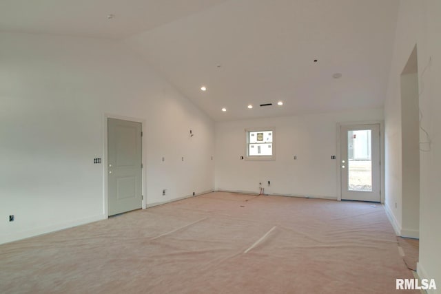 spare room with light colored carpet and high vaulted ceiling