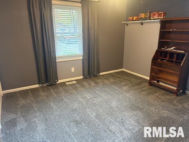 unfurnished bedroom with dark colored carpet