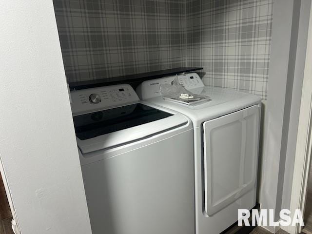 clothes washing area featuring dark hardwood / wood-style flooring and washing machine and dryer