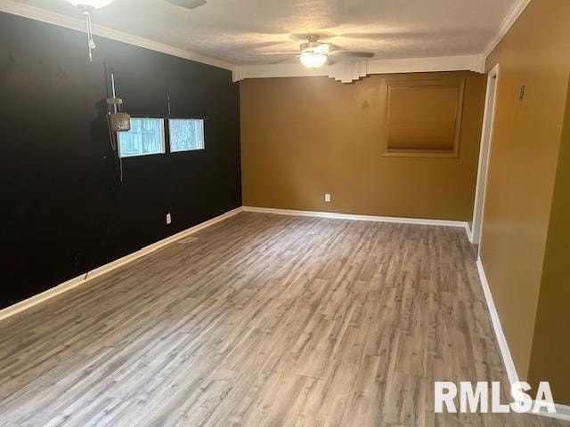 spare room featuring ceiling fan, wood-type flooring, and ornamental molding