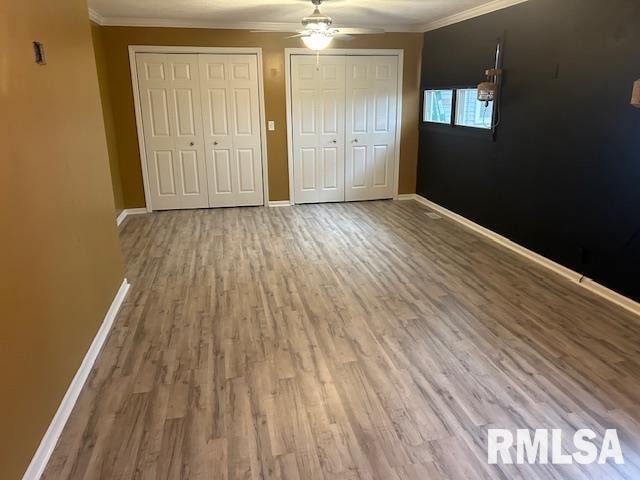 unfurnished bedroom featuring hardwood / wood-style flooring, ceiling fan, and crown molding