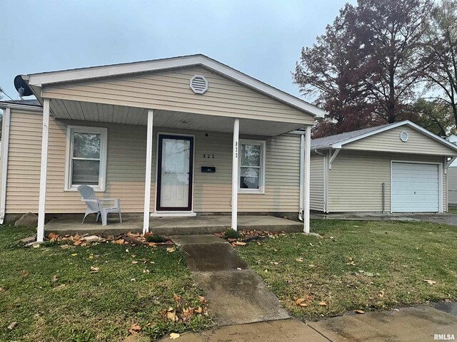 view of front of property with a porch, a front lawn, and a garage