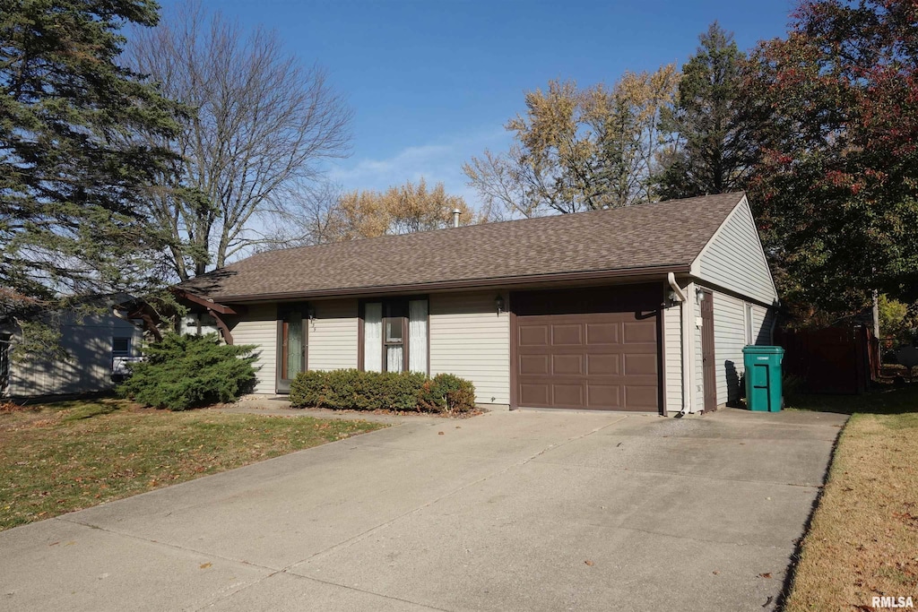 view of front of home featuring concrete driveway, a shingled roof, an attached garage, and a front yard