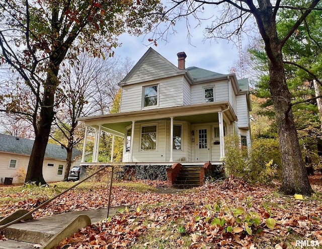 victorian home with covered porch and a chimney