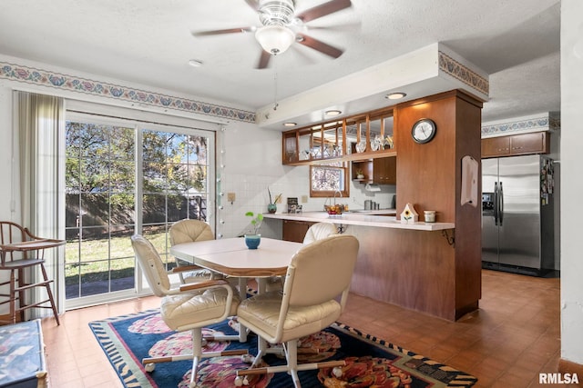 dining area featuring ceiling fan and a textured ceiling