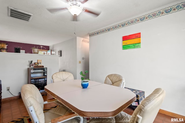 tiled dining room with ceiling fan and a textured ceiling