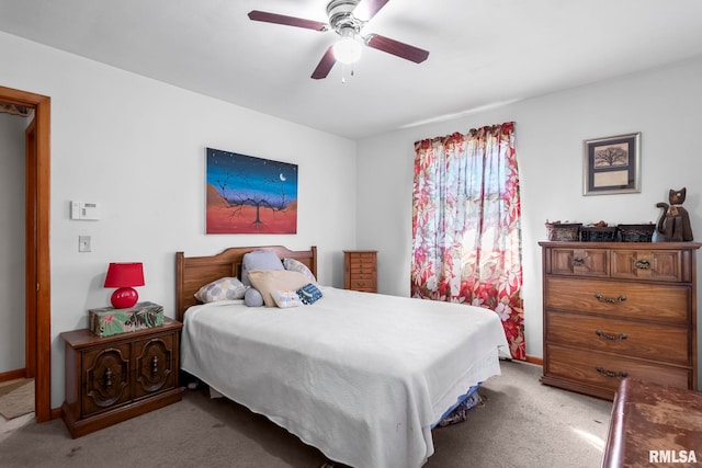 bedroom featuring baseboards, light carpet, and ceiling fan