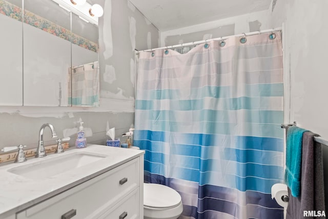 full bath featuring toilet, curtained shower, and vanity
