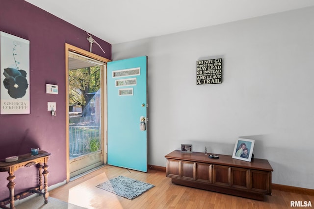 doorway to outside with light wood-style flooring and baseboards