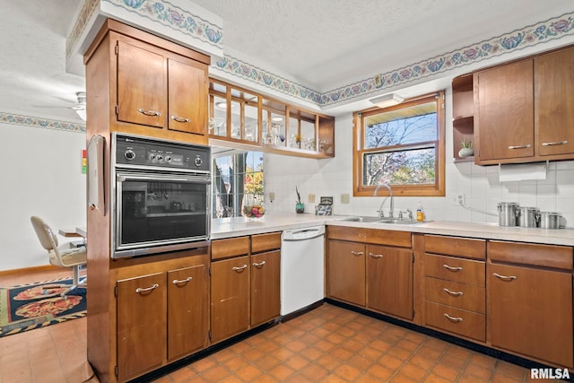 kitchen featuring a sink, open shelves, black oven, a textured ceiling, and dishwasher