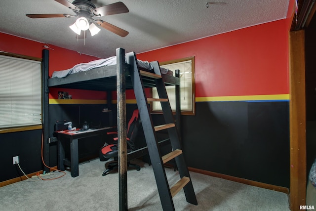 bedroom featuring carpet flooring, a textured ceiling, and ceiling fan