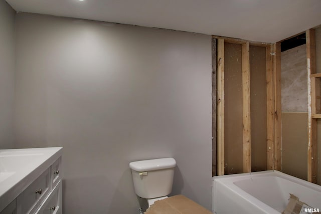 bathroom with vanity, a washtub, and toilet