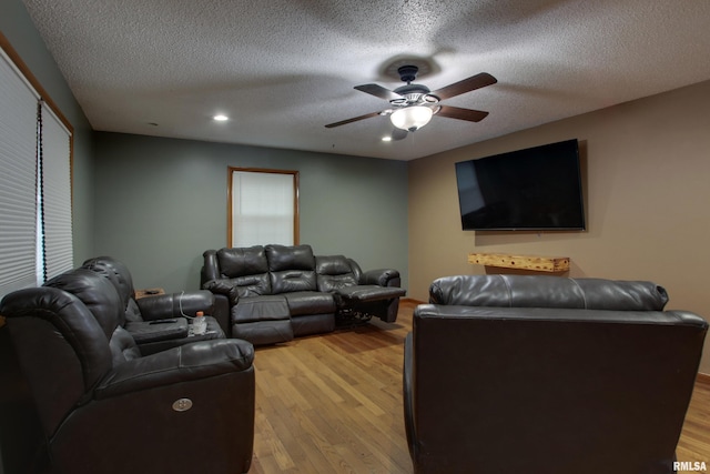 home theater with light hardwood / wood-style floors, a textured ceiling, and ceiling fan