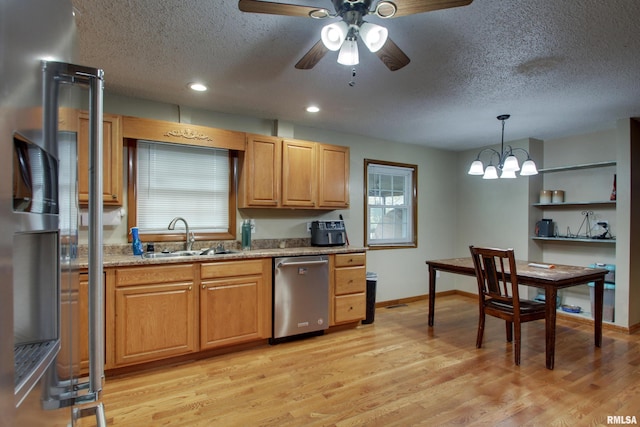 kitchen featuring light stone counters, pendant lighting, sink, dishwasher, and light hardwood / wood-style flooring