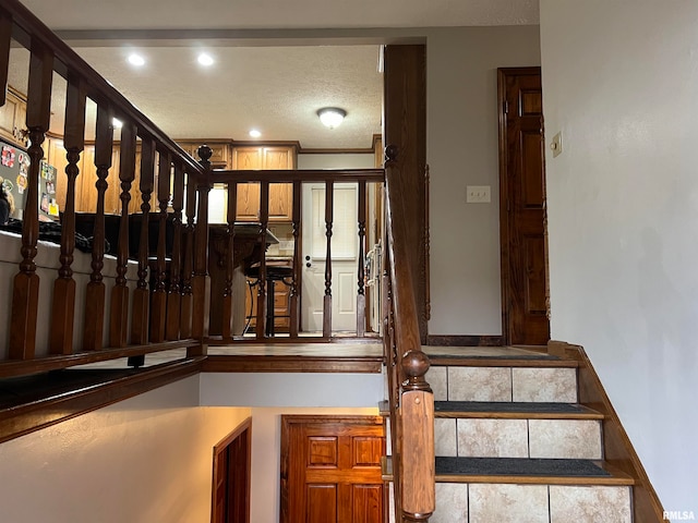 stairs featuring a textured ceiling