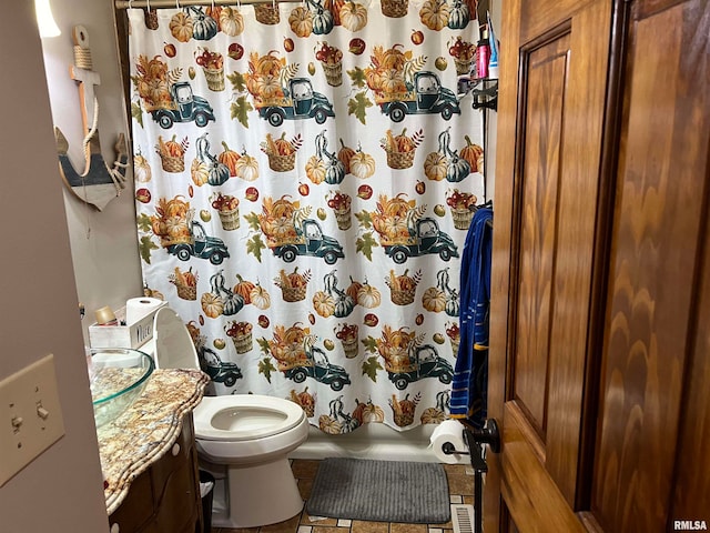 bathroom featuring toilet, vanity, tile patterned flooring, and walk in shower