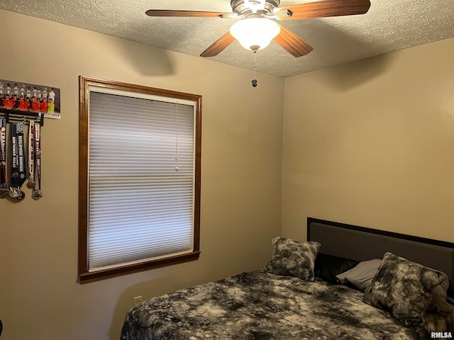 bedroom with ceiling fan and a textured ceiling