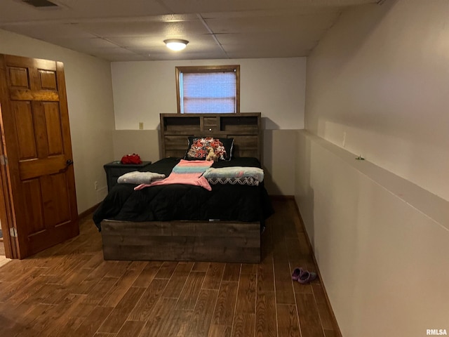 bedroom featuring dark hardwood / wood-style flooring and a drop ceiling