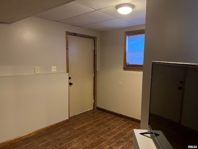 spare room with dark hardwood / wood-style floors and a drop ceiling