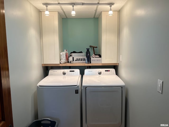 washroom featuring washing machine and dryer and cabinets