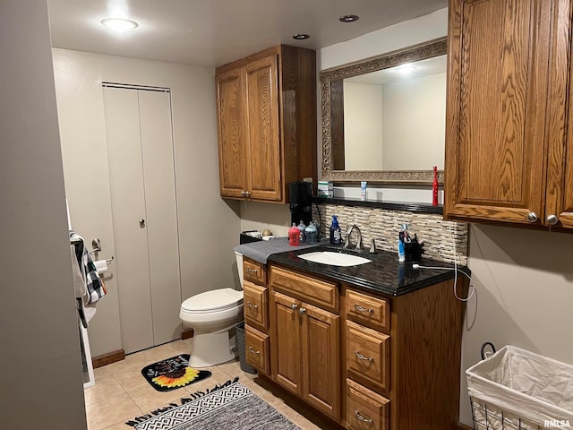 bathroom featuring toilet, backsplash, vanity, and tile patterned flooring