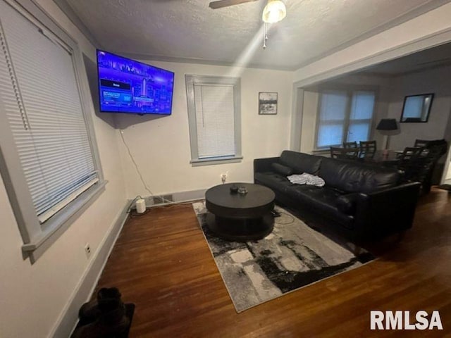 living room with hardwood / wood-style flooring, a textured ceiling, and ceiling fan