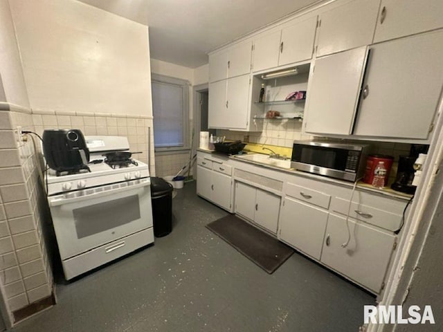 kitchen with white cabinetry, sink, and white gas stove